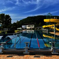 Das Bild zeigt ein Freibad mit Rutsche.