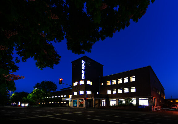 Das Bild zeigt DasBad" ein Hallenbad in Trier von außen bei Nacht.