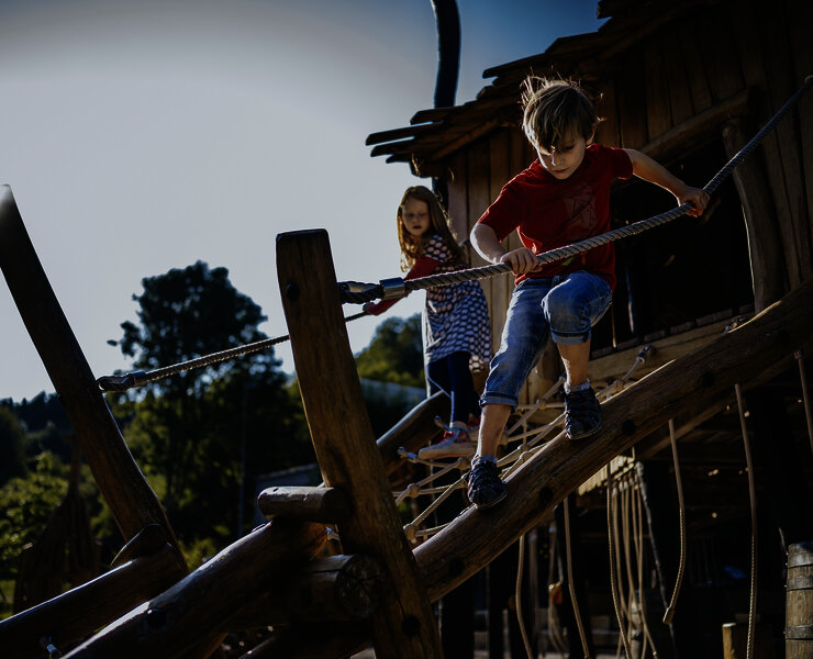 Das Bild zeigt zwei Kinder, die auf einem Klettergerüst eines Spielplatzes beim Freizeitzentrum Peterberg klettern.