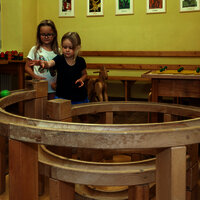 Das Bild zeigt zwei Mädchen, die mit einer Kugelbahn im Spielzimmer des Hunsrücker Holzmuseums spielen.