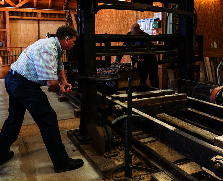 Das Bild zeigt einen Mann, der im Drechselraum des Hunsrücker Holzmuseum eine alte Maschine bedient im Rahmen einer Gästeführung.