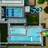 Das Foto zeigt die Gesamtanlage des Vitteliusbad Wittlich, mit Hallenbad, Freibad, Rutschen, Liegewiesen und Kinderbereich.