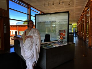 Das Bild zeigt eine römische Figur und die Dauerausstellung im Kulturzentrum Belginum Archäologiepark.