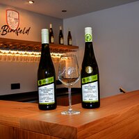 Weinflaschen und Weinglas im Thekenbereich