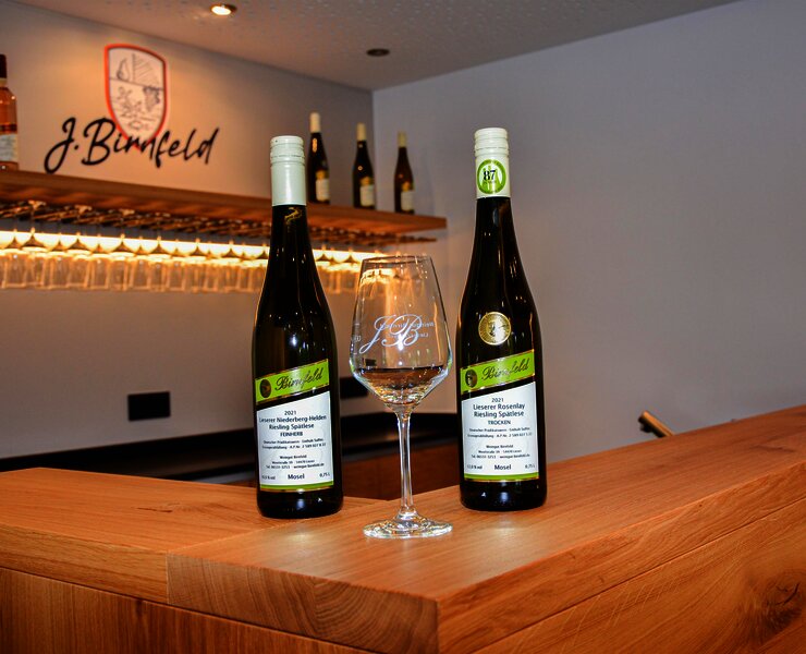 Weinflaschen und Weinglas im Thekenbereich