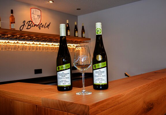 Weinflaschen und Weinglas im Thekenbereich