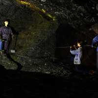 Das Foto zeigt einen Stollen mit Menschenpuppen als Arbeiter im Besucherbergwerk Fell.