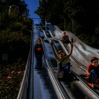 Das Bild zeigt mehrere Kinder, die die Teppichrutsche beim Freizeitzentrum Peterberg runterrutschen.