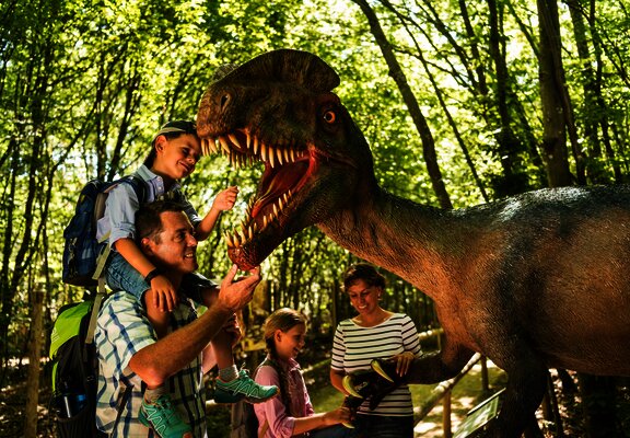 Das Bild zeigt eine Familie im Dinopark Teufelsschlucht.