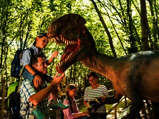 Das Bild zeigt eine Familie im Dinopark Teufelsschlucht.