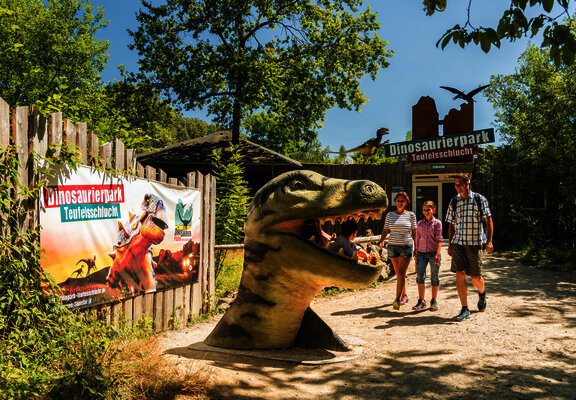Das Bild zeigt eine Familie im Dinopark Teufelsschlucht.