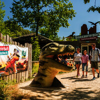 Das Bild zeigt eine Familie im Dinopark Teufelsschlucht.