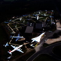 Das Bild zeigt eine Luftaufnahme vom Gelände der Flugausstellung Junior mit zahlreichen Flugzeugen und dem Hauptgebäude.