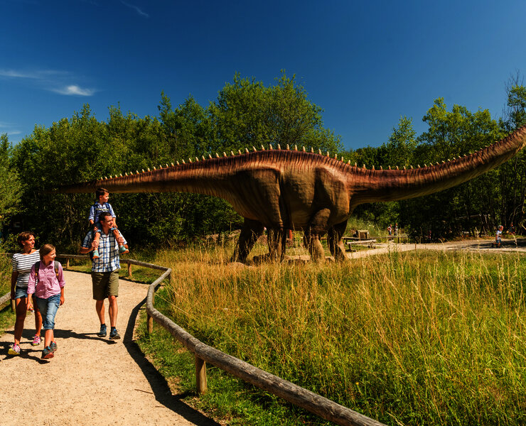 Das Bild zeigt eine Familie im Dinopark Teufelsschlucht.