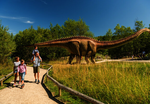 Das Bild zeigt eine Familie im Dinopark Teufelsschlucht.